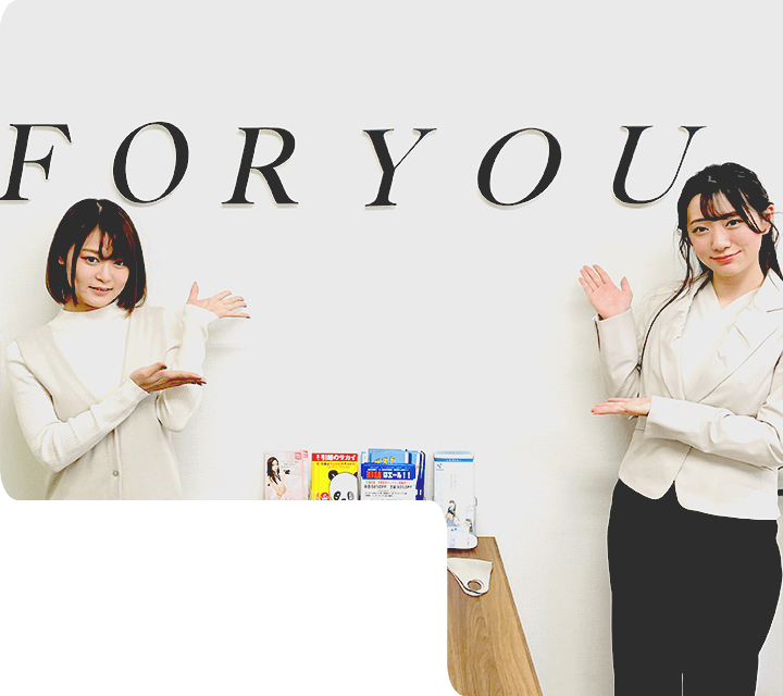 株式会社フォーユーの女性スタッフ2名がFORYOUの看板前でポーズを取っているところ