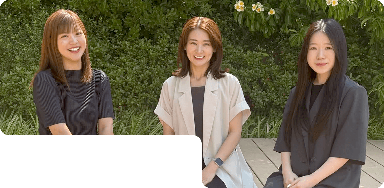 株式会社フォーユーのスタッフ3名が屋外で並んで座っている様子