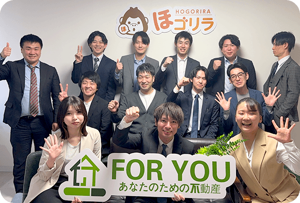 先輩スタッフがパソコン画面を指差しながら新入社員に業務を教えている様子
